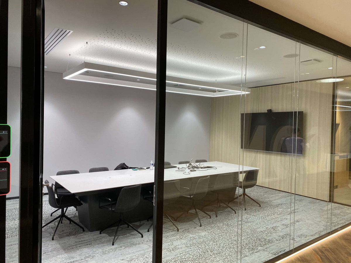 Une salle de réunion spacieuse avec un éclairage moderne équipé d'une grande table. Cela crée un environnement professionnel.