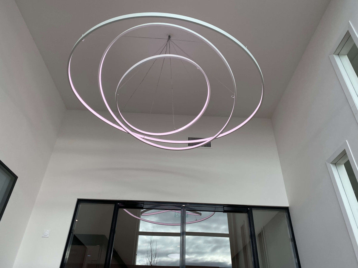 Un plafonnier moderne en spirale. L'éclairage est blanc. 