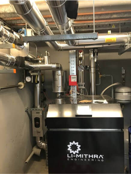 Local technique avec équipements de chauffage et ballon de stockage Li-Mithra raccordé à un réseau de tuyauterie.