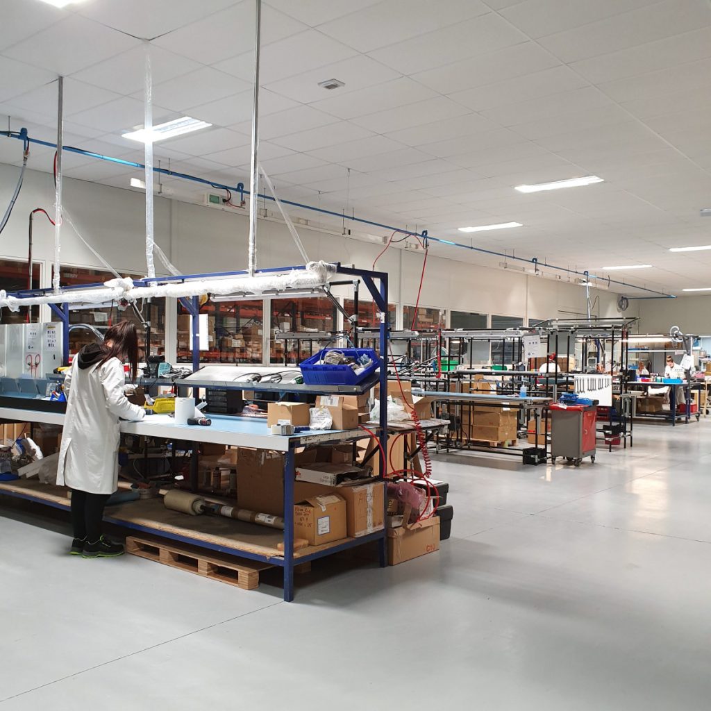 Vue de l’atelier de fabrication de Bio Power Lighting (DLS) avec plusieurs personnes en train de travailler sur les postes de production.