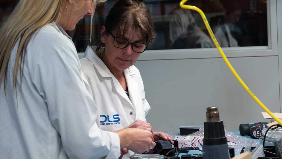 Deux techniciennes réalisent le montage d’un luminaire.